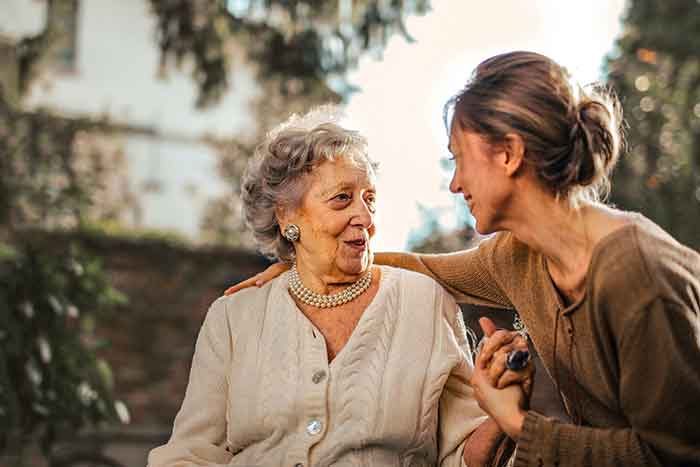 a senior woman speaking with a younger woman